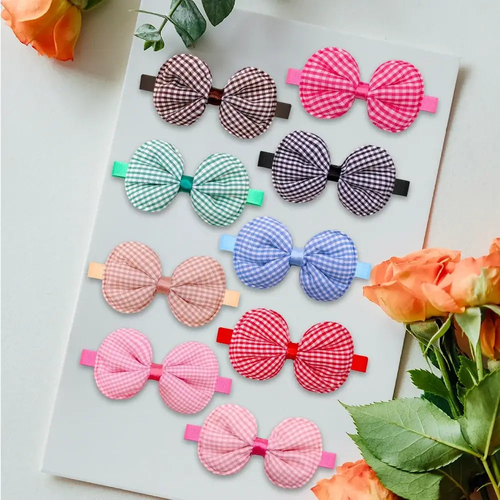 A collection of colorful fabric bow hair clips in gingham and solid patterns for small dog and cat bow ties