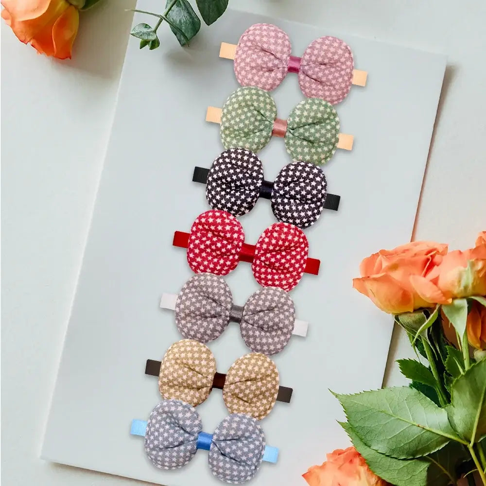 A set of seven small dog and cat fabric bow hair clips in pastel and neutral tones with checkered pattern and elastic bands