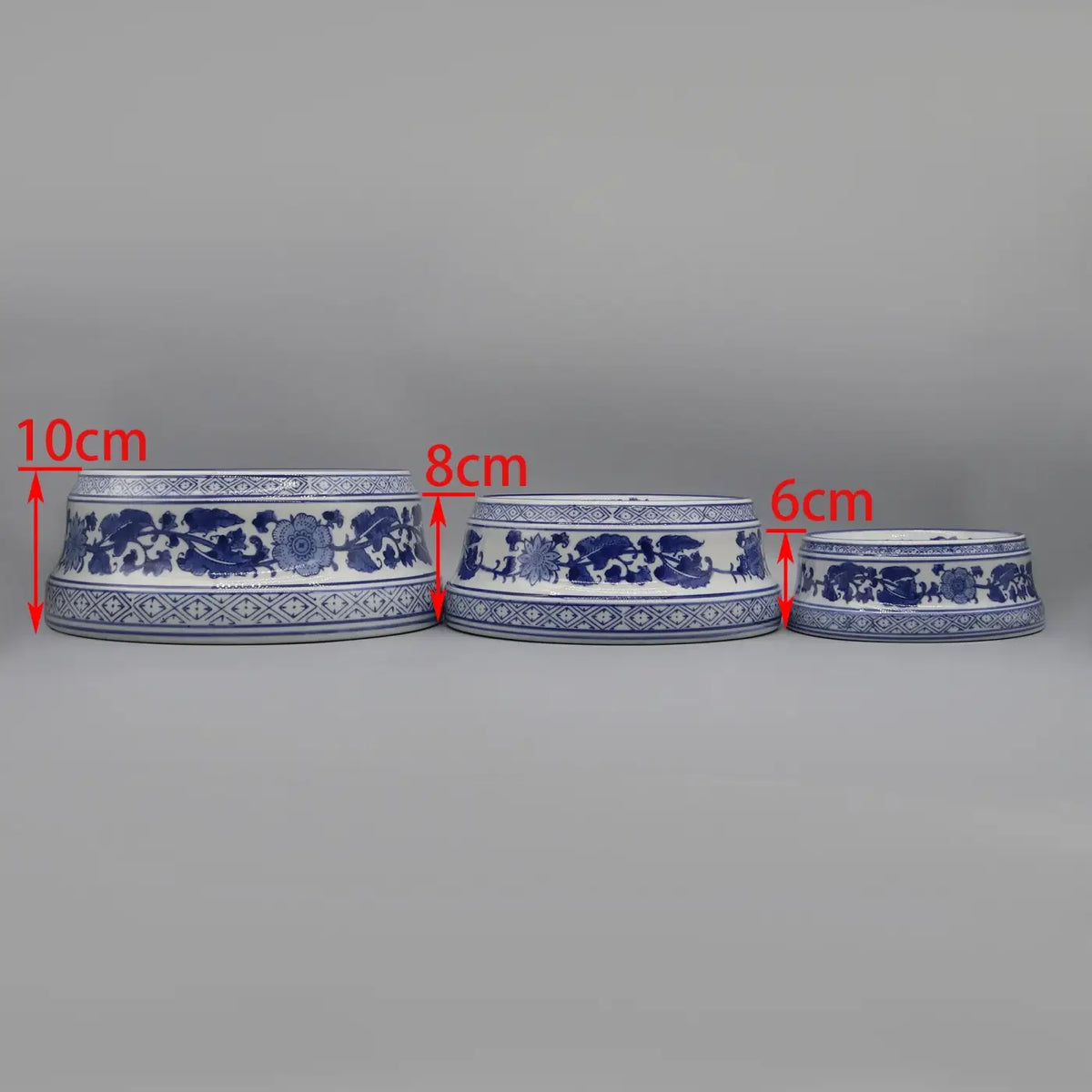 Three ceramic pet feeding bowls in blue and white porcelain with intricate floral patterns along the rim