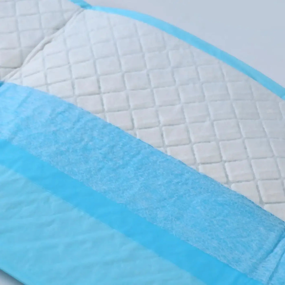 White quilted parrot pee pad with light blue textured border and absorbent strips for bird cage liners