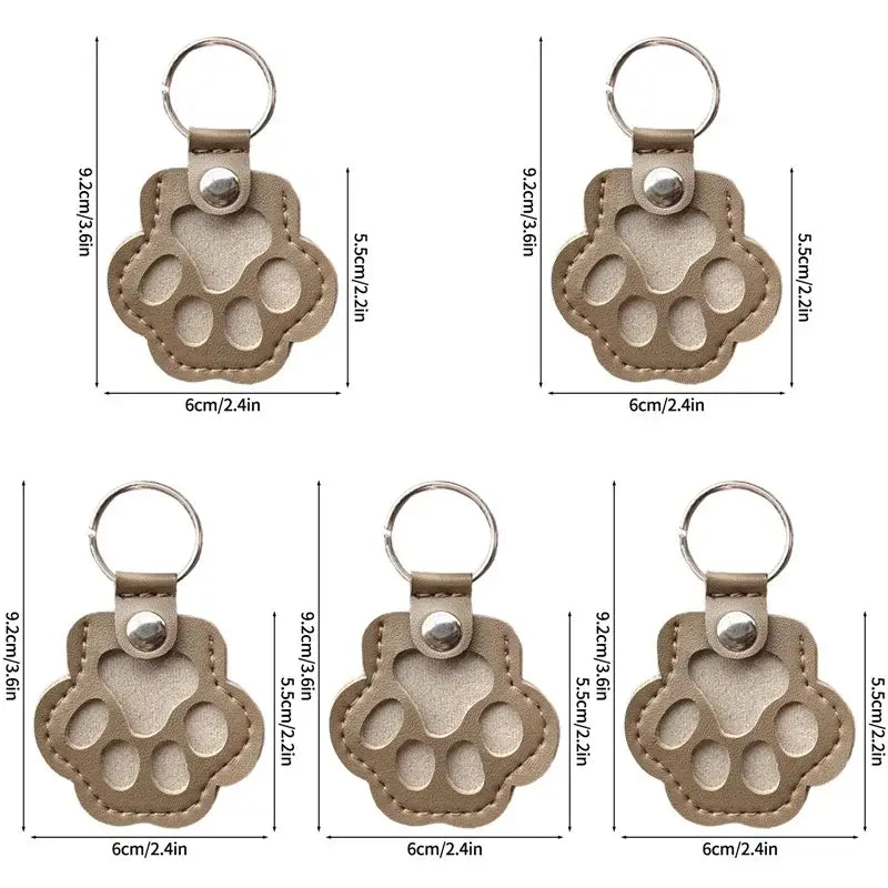 Tan leather paw print pet fur memorial keepsake keychain with stitched edges and silver metal ring for hair storage