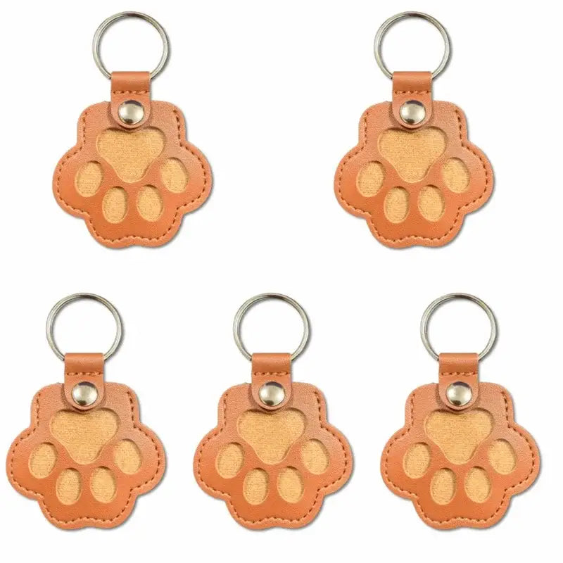 Tan leather pet fur memorial keepsake keychain shaped like a paw print with stitched edges and metallic ring