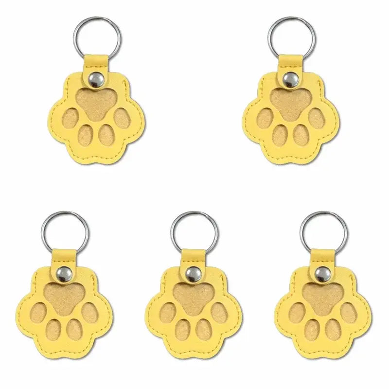 Yellow paw-shaped leather pet fur memorial keepsake keychain with silver metal ring and button hair storage bag