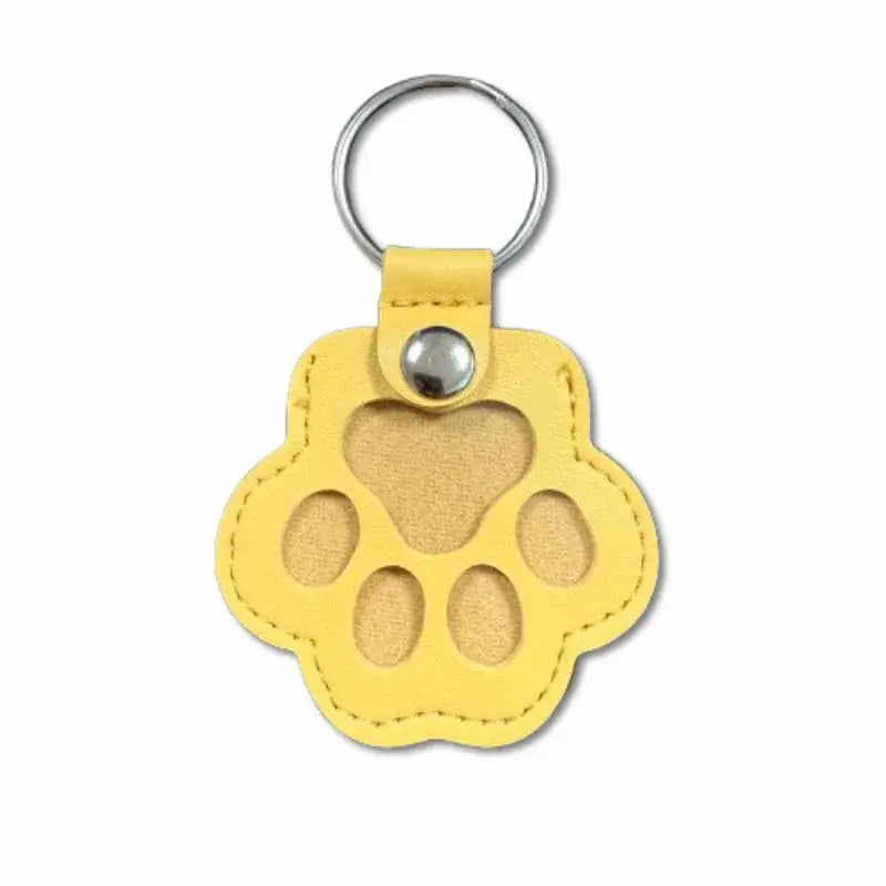 Yellow leather paw print keychain with silver metal ring and snap button for pet fur memorial keepsake and hair storage