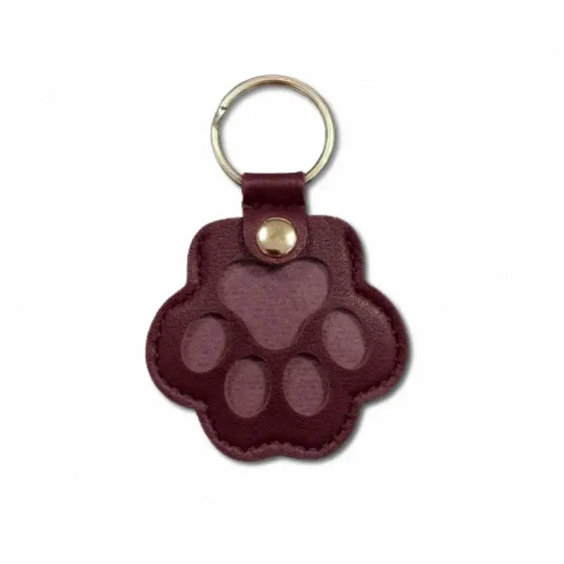 Maroon leather paw print keychain with stitched edges and gold metal ring for pet fur memorial keepsake and hair storage