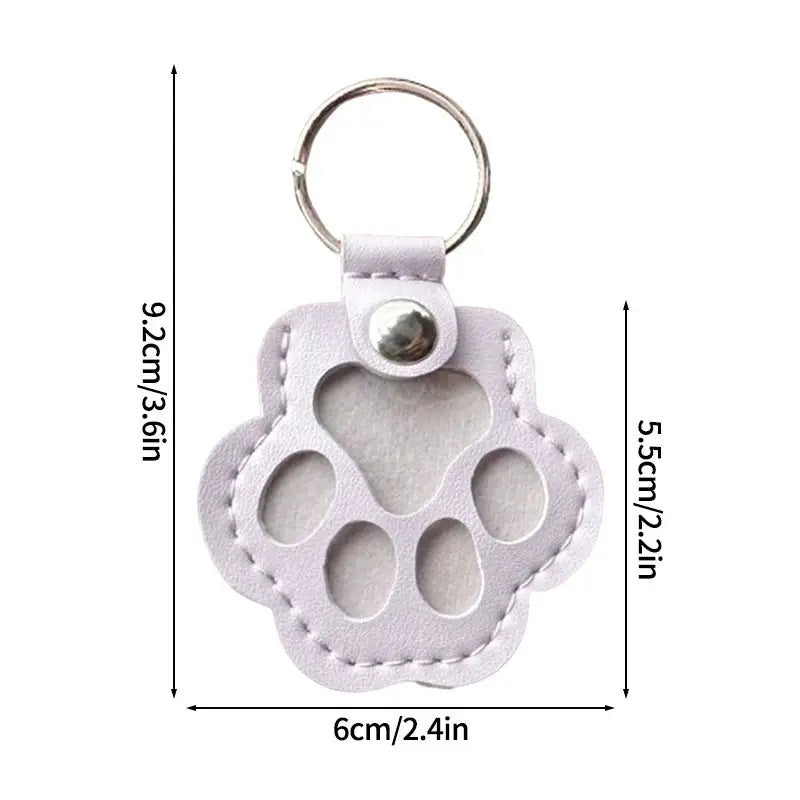 Pet fur memorial keepsake keychain and hair storage bag featuring a light purple leather paw print with stitched edges and silver metal ring