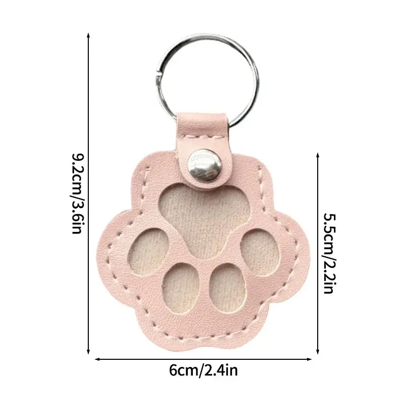 Pink leather paw print keychain with stitched edges and silver ring for pet fur memorial keepsake and hair storage bag