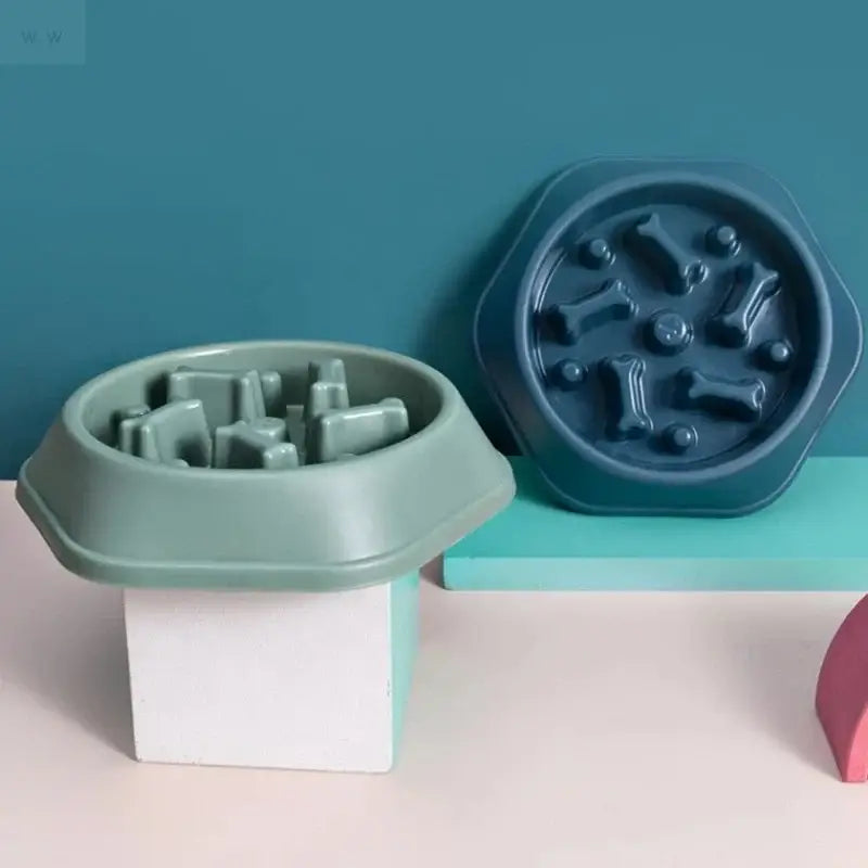 Two silicone slow feeder dog bowls in sage green and dark teal with raised bones for anti-choking feeding supplies