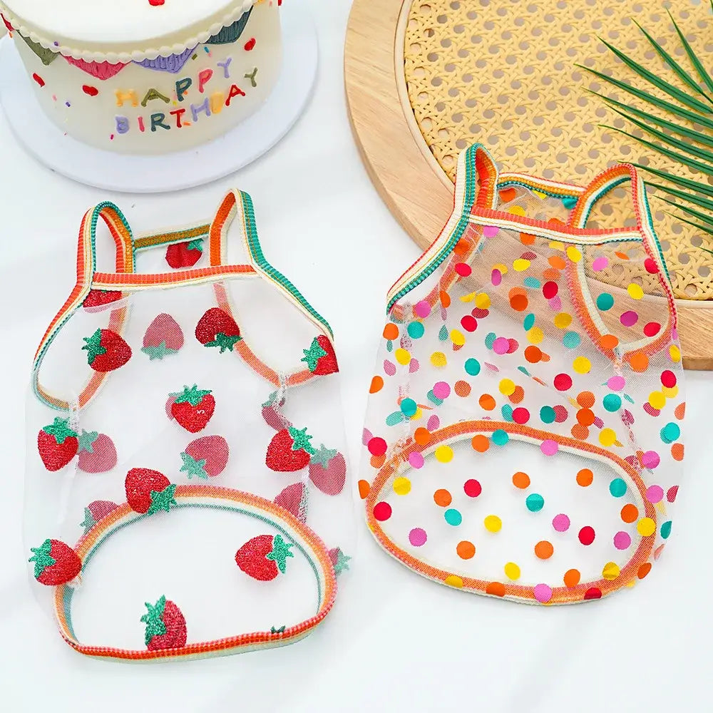 Transparent pet sunscreen vests with glittery red strawberries and multicolored dots outlined in orange trim for dogs and cats