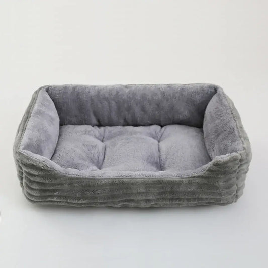 Gray plush rectangular pet bed with soft textured fabric and tufted cushioning for small and medium dogs calming use