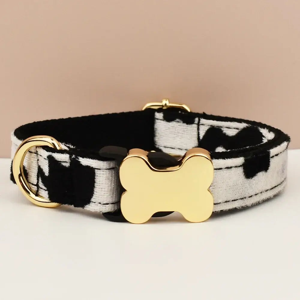 Premium custom engraved dog collar with black and white cow print and gold bone-shaped buckle for durable comfortable fit
