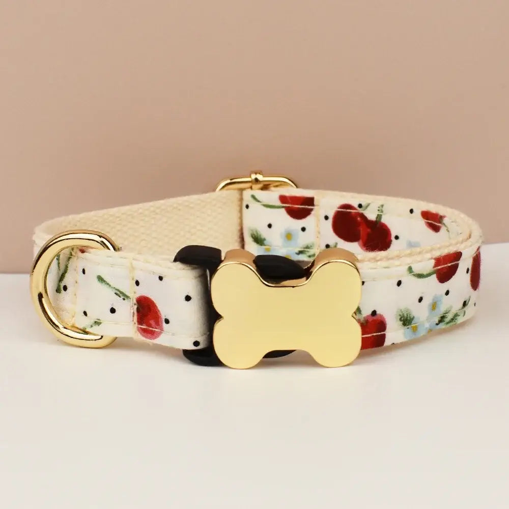 Premium custom engraved white fabric dog collar with cherry floral pattern and gold-tone bone hardware for all dog sizes