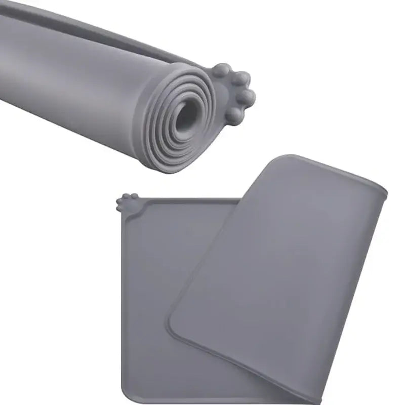 Gray waterproof silicone pet feeding mat with paw-print design at one end for easy cleaning and durability