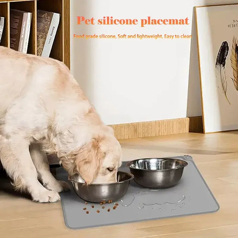 Gray waterproof silicone pet feeding mat with non-slip surface holds two metal pet bowls securely